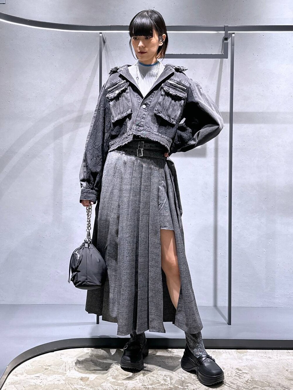 ブラック系のショルダーバッグ、シルバー系のブーツ、グレー系のニット/セーターを着用したレディースの秋コーディネートの1枚目の写真