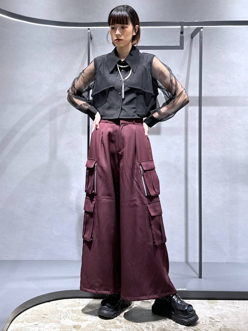ブラック系のサンダル、ブラック系のシャツ/ブラウス、レッド系のカーゴパンツを着用したレディースの夏コーディネートの1枚目の写真