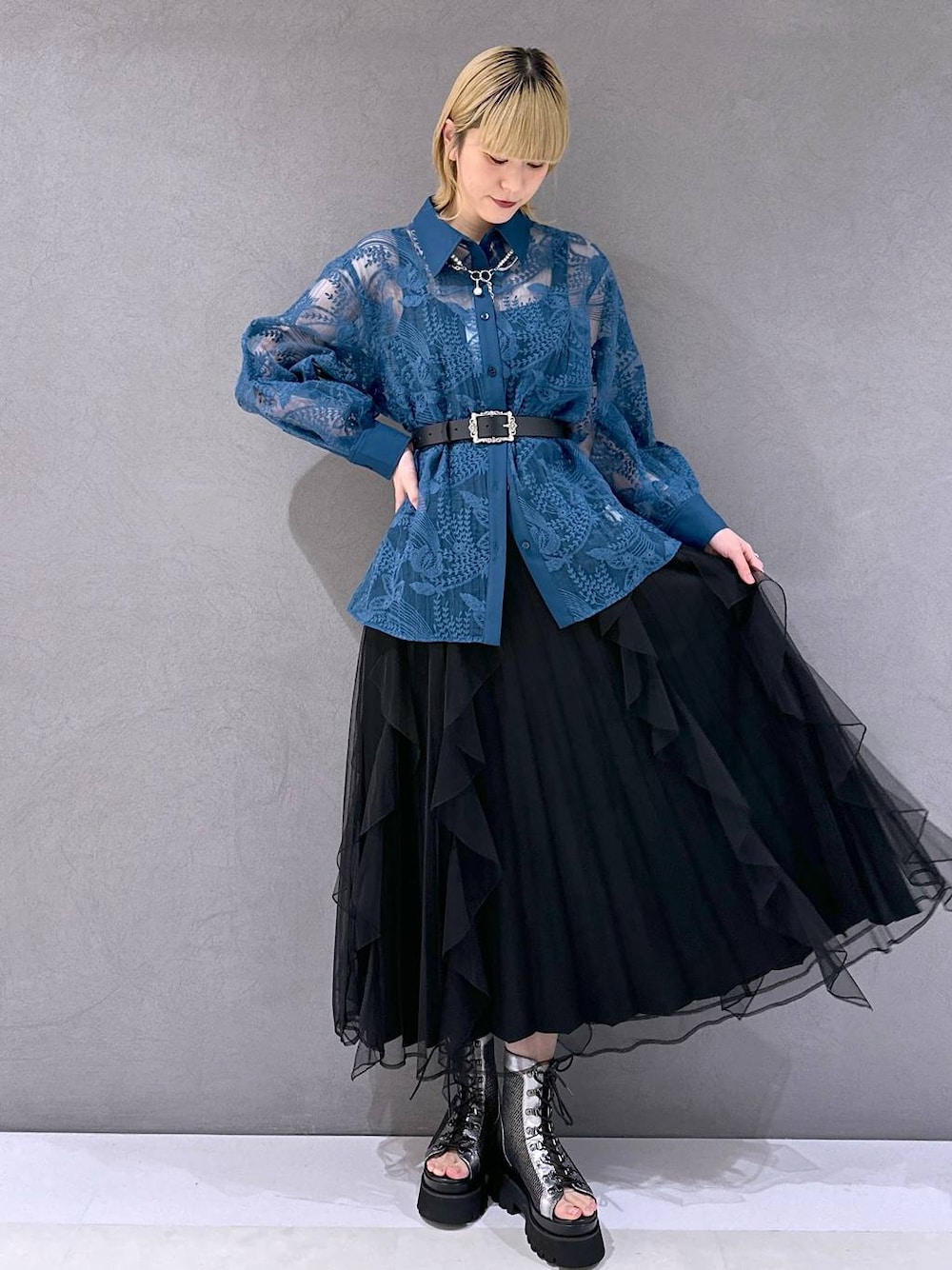 シルバー系のサンダル、ブラック系のスカート、ブルー系のシャツ/ブラウスを着用したレディースの春コーディネートの1枚目の写真