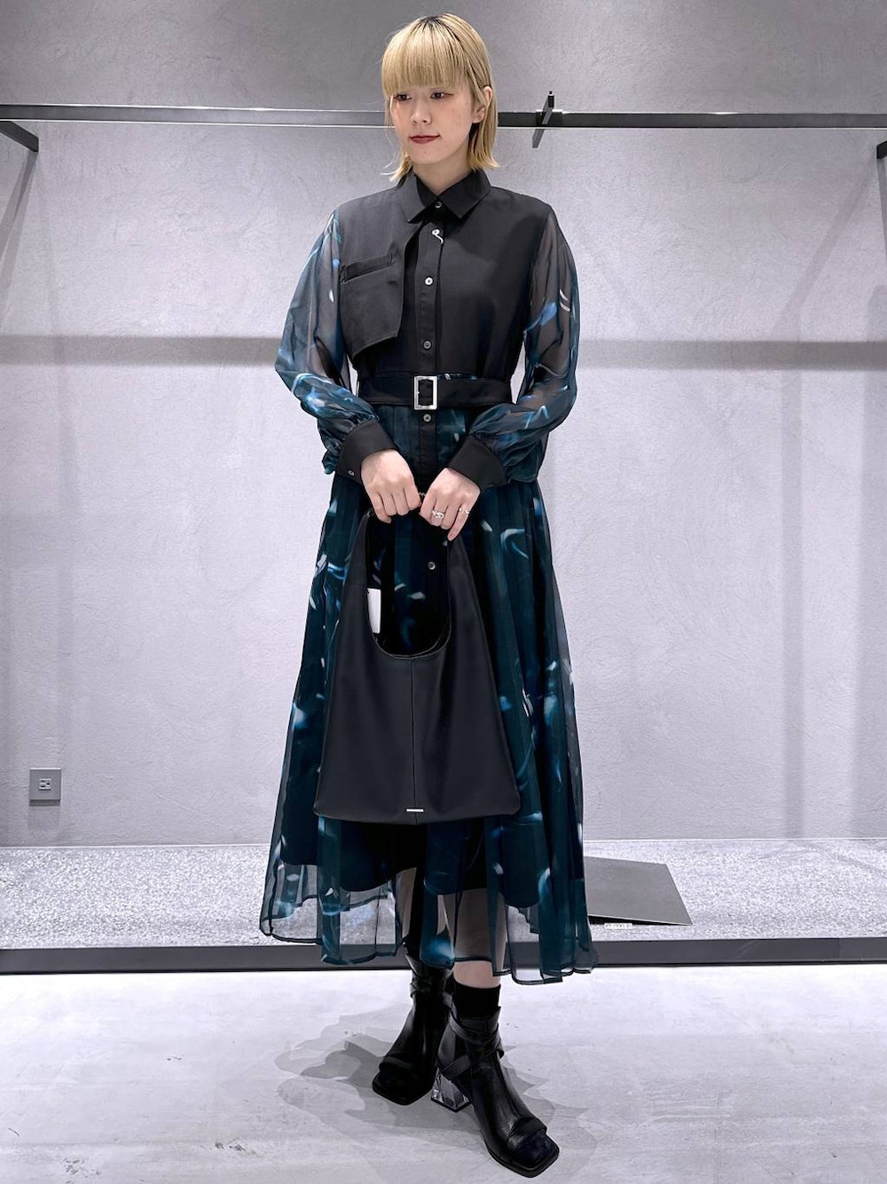 ブラック系のトートバッグ、ブラック系のサンダルを着用したレディースの春コーディネートの1枚目の写真