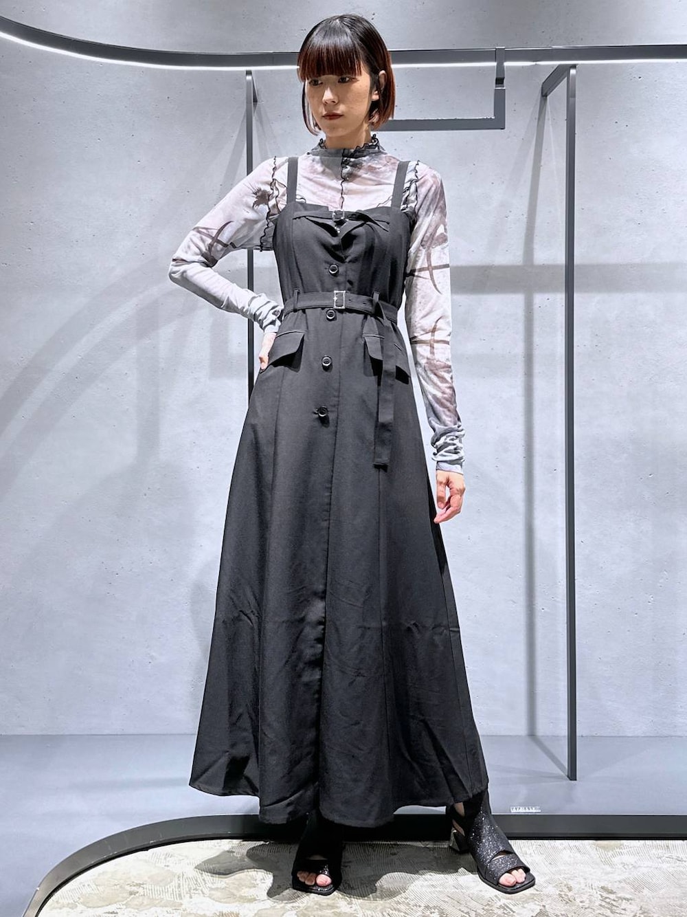 ブラック系のサンダル、ブラック系のジャンパースカート、ホワイト系のTシャツ/カットソーを着用したレディースの夏コーディネートの1枚目の写真