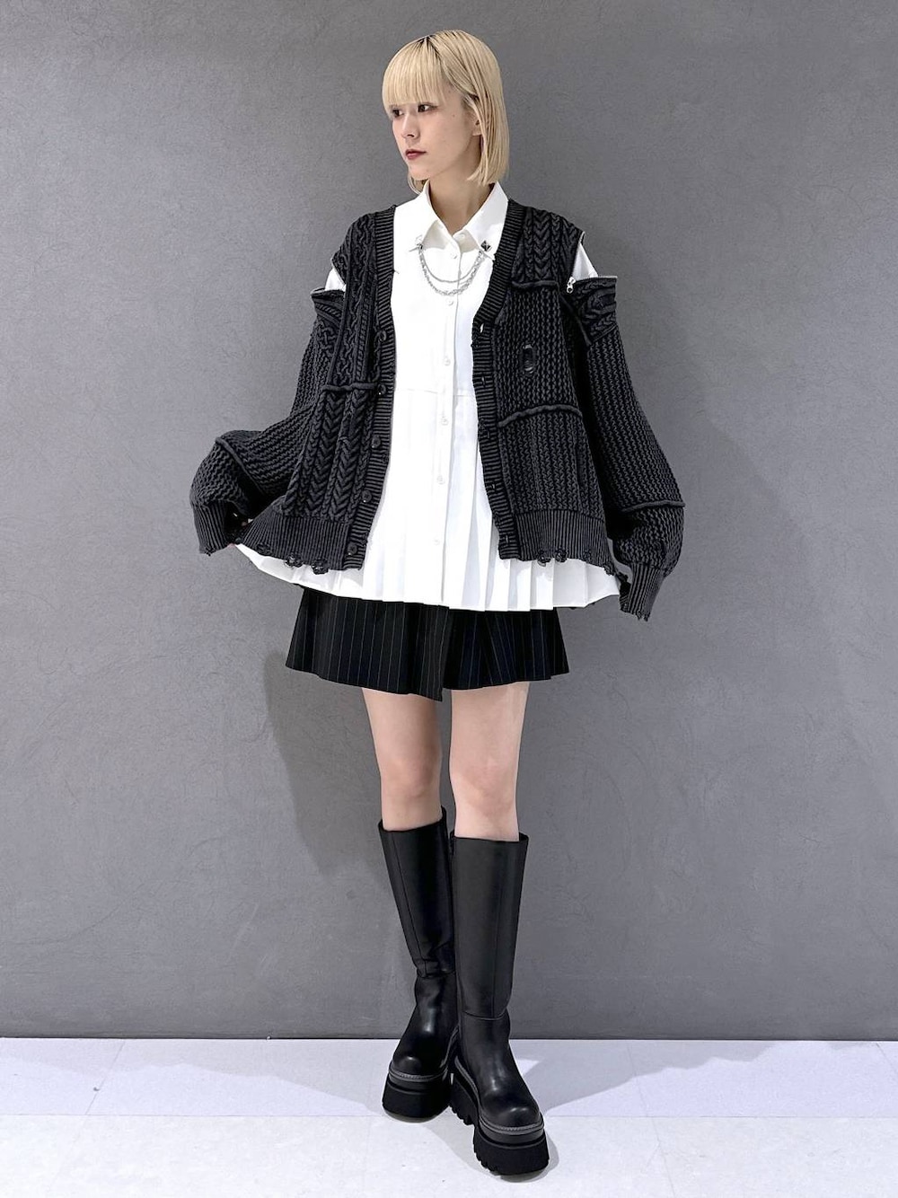 ブラック系のその他パンツ、ブラック系のカーディガン/ボレロ、ブラック系のブーツを着用したレディースの秋コーディネートの1枚目の写真