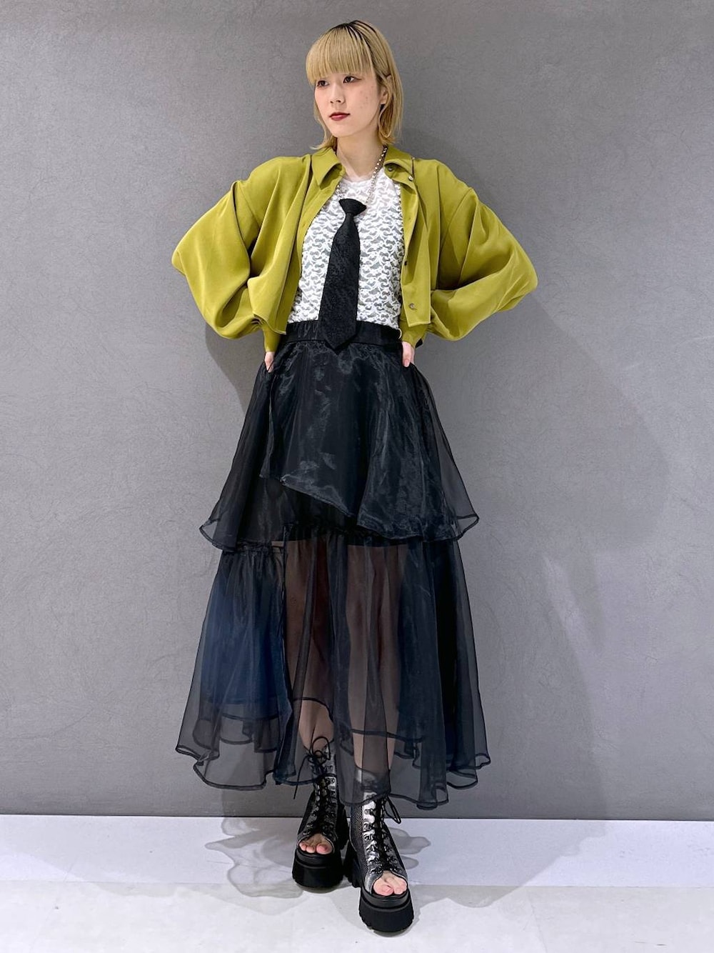 ブラック系のネクタイ、シルバー系のサンダル、イエロー系のシャツ/ブラウスを着用したレディースの春コーディネートの1枚目の写真