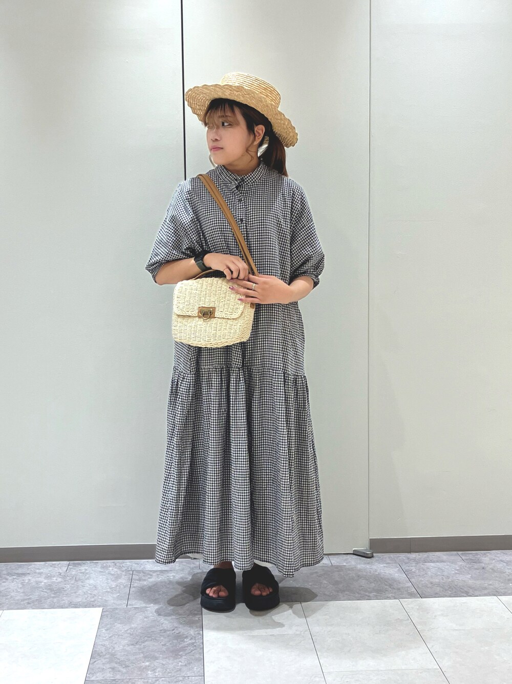 ホワイト系のハンドバッグ、ブラック系のワンピース、ブラック系のサンダルを着用したレディースの夏コーディネートの1枚目の写真