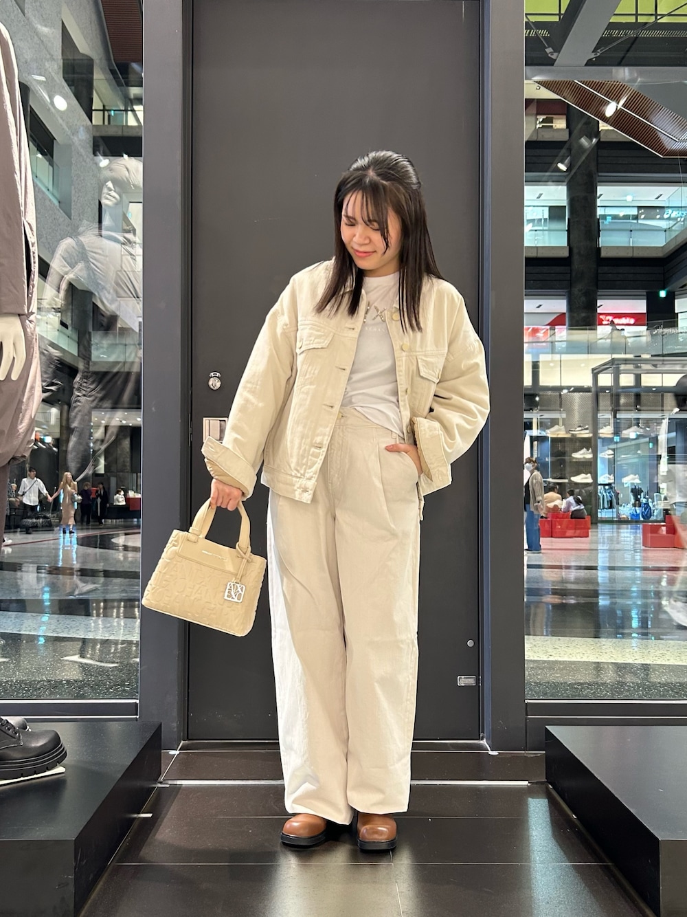 イエロー系のブーツ、ベージュ系のデニムパンツ、ホワイト系のTシャツ/カットソーを着用したレディースの秋コーディネートの1枚目の写真