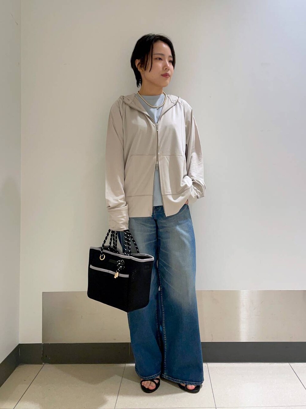 グリーン系のTシャツ/カットソー、グレー系のパーカー、ブラック系のトートバッグを着用したレディースの春コーディネートの1枚目の写真