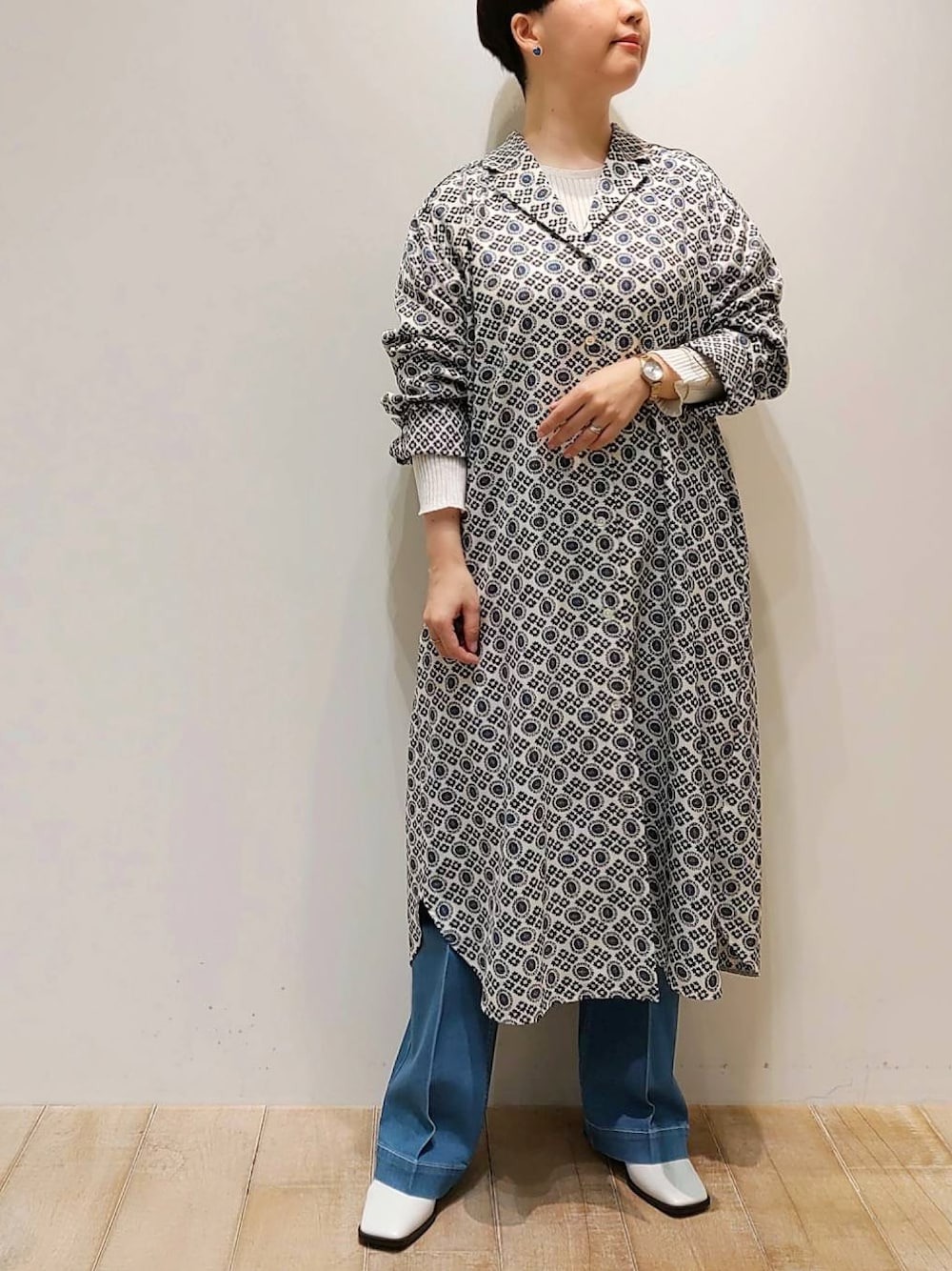 ブルー系のワンピース、ブルー系のデニムパンツ、ホワイト系のニット/セーターを着用したレディースの冬コーディネートの1枚目の写真