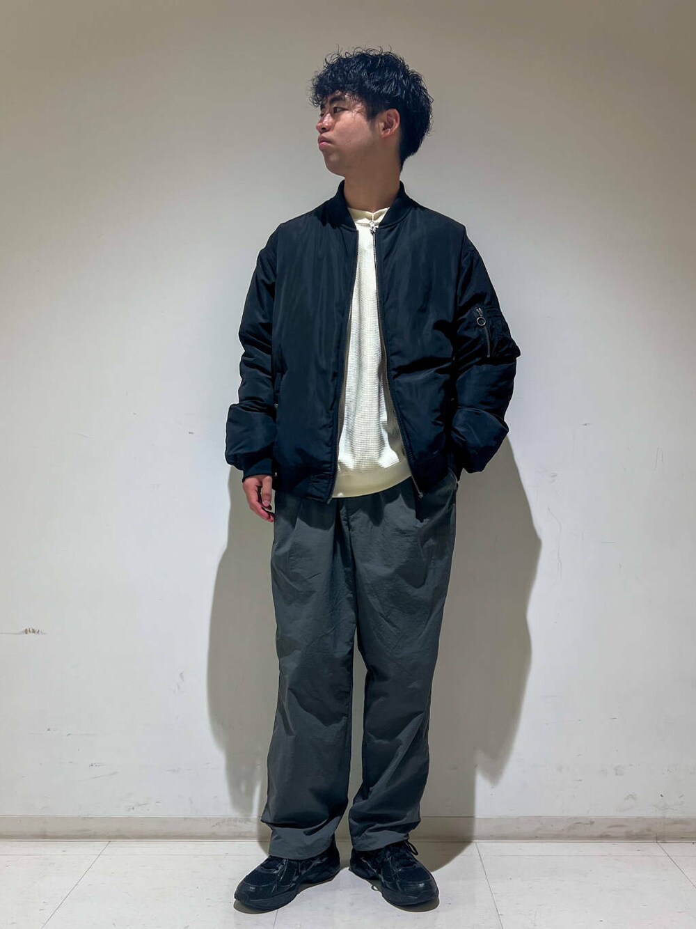 グレー系のその他パンツ、ホワイト系のTシャツ/カットソー、ブラック系のMA-1を着用したメンズの秋コーディネートの1枚目の写真