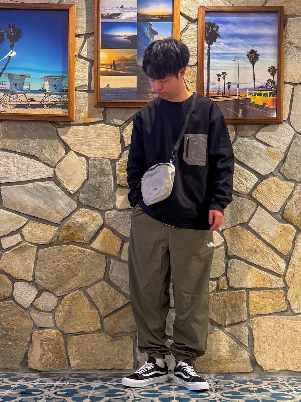 グリーン系のその他パンツ、グレー系のショルダーバッグ、ブラック系のTシャツ/カットソーを着用したメンズの春コーディネートの1枚目の写真