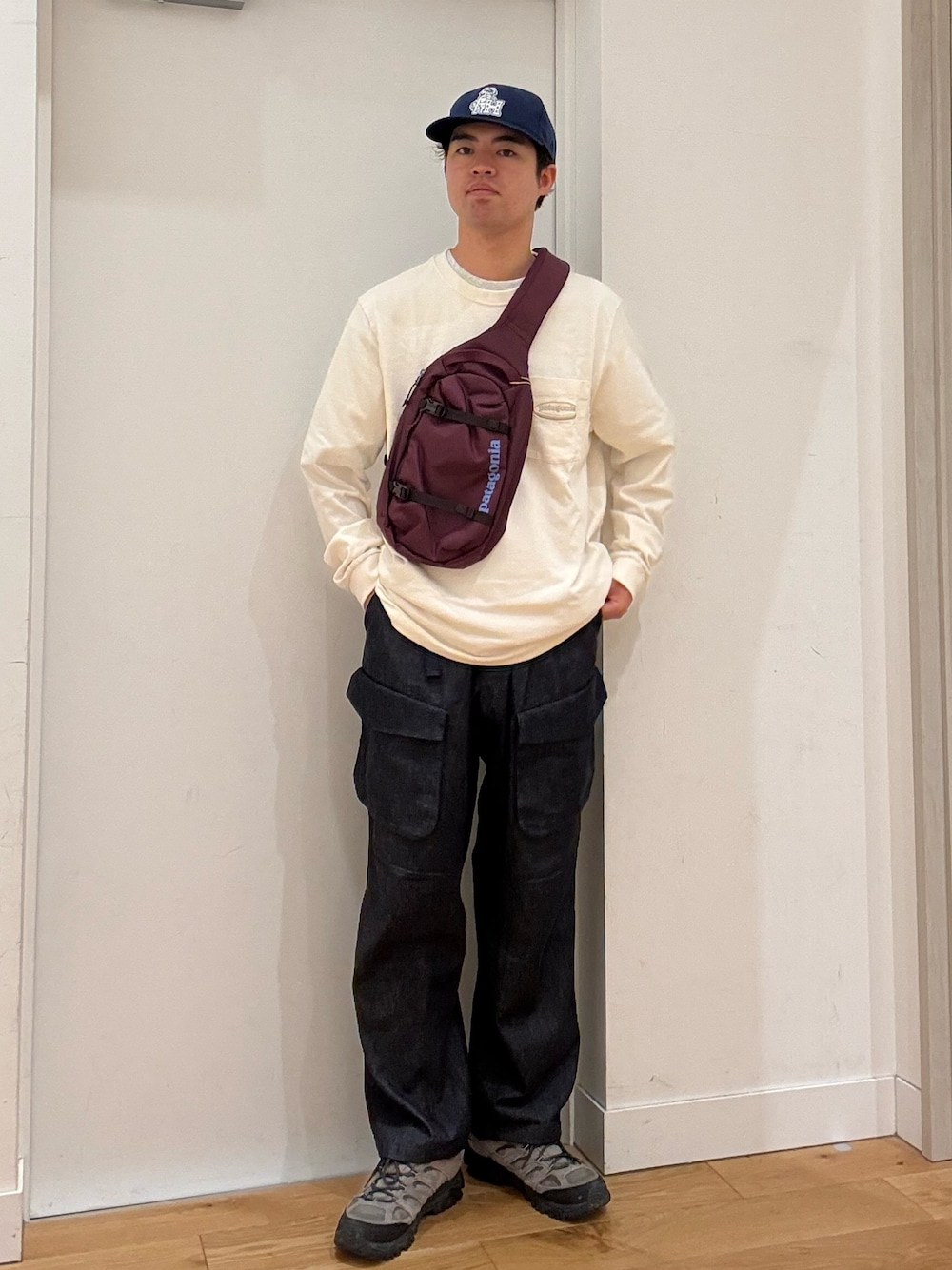 レッド系のショルダーバッグ、ホワイト系のTシャツ/カットソー、グレー系のスニーカーを着用したメンズの秋コーディネートの1枚目の写真