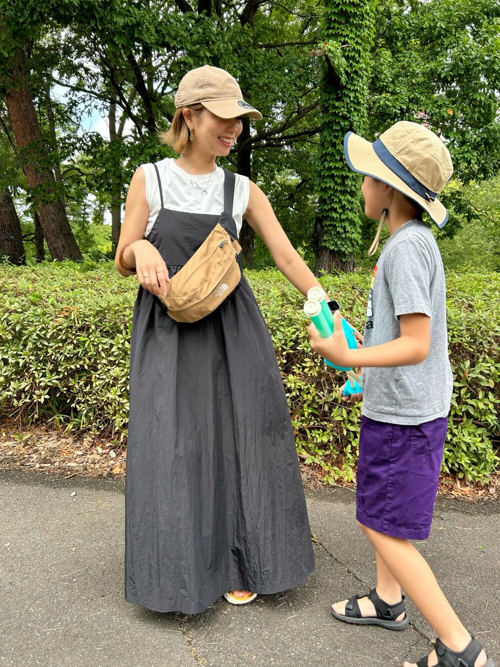 ブラック系のワンピース、ブラウン系のボディバッグ/ウエストポーチ、その他のサンダルを着用したレディースの夏コーディネートの1枚目の写真