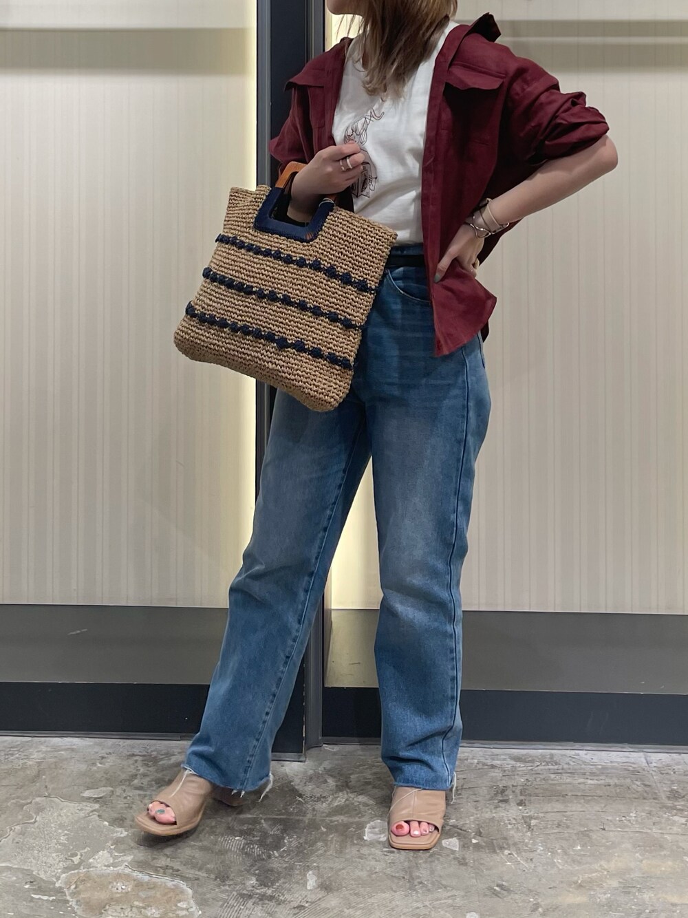 レッド系のシャツ/ブラウス、ブルー系のデニムパンツ、ベージュ系のサンダルを着用したレディースの夏コーディネートの1枚目の写真