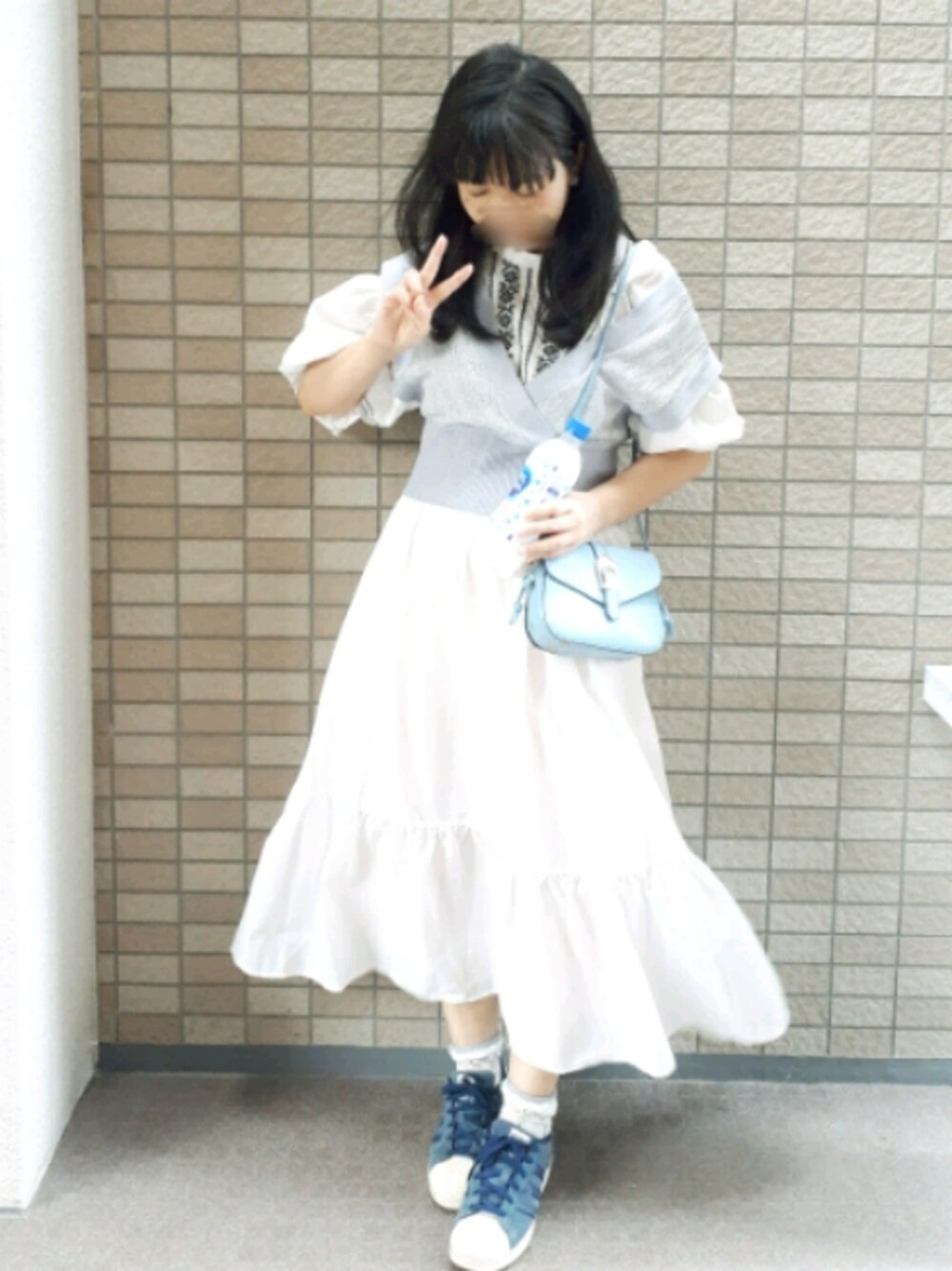 ブルー系のベスト、ホワイト系のワンピース、ブルー系のスニーカーを着用したレディースの秋コーディネートの1枚目の写真