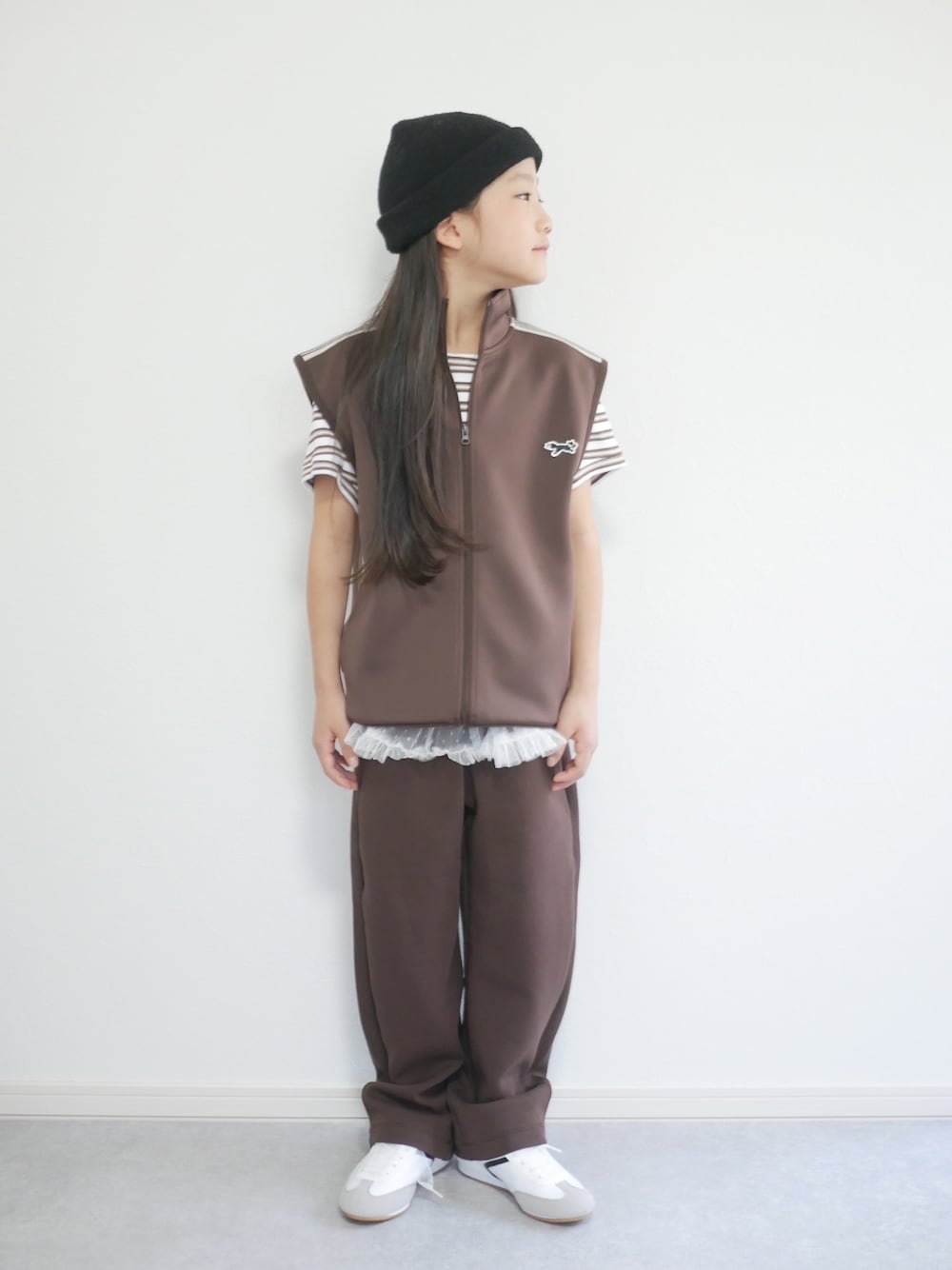 ブラウン系のTシャツ/カットソー、ホワイト系のスカート、ブラック系のスウェットパンツを着用したキッズの秋コーディネートの1枚目の写真
