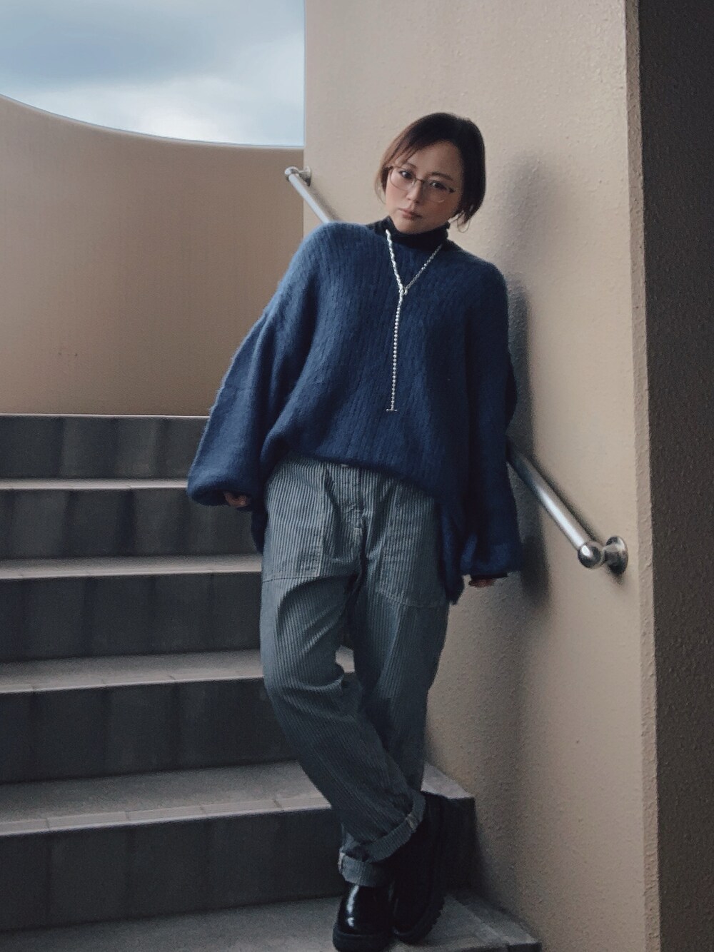 ブルー系のニット/セーター、ブラック系のTシャツ/カットソー、ブルー系のその他パンツを着用したレディースの冬コーディネートの1枚目の写真