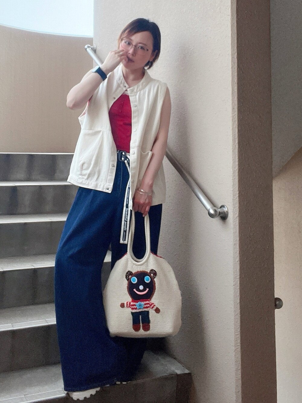 レッド系のタンクトップ、ホワイト系のベスト、ホワイト系のサンダルを着用したレディースの夏コーディネートの1枚目の写真