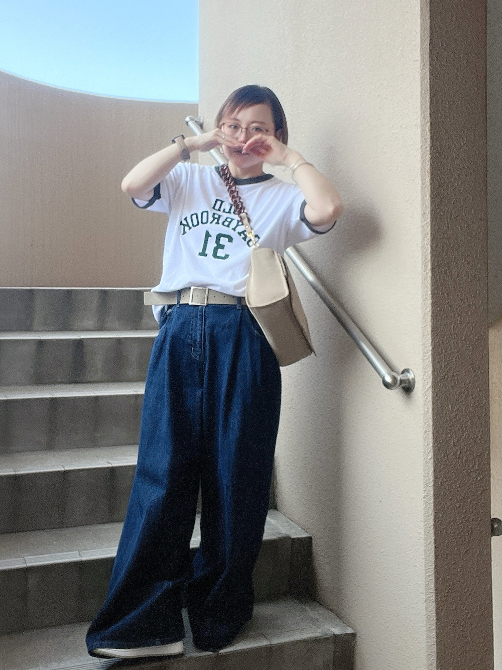 ホワイト系のTシャツ/カットソー、ブルー系のデニムパンツ、ベージュ系のショルダーバッグを着用したレディースの夏コーディネートの1枚目の写真
