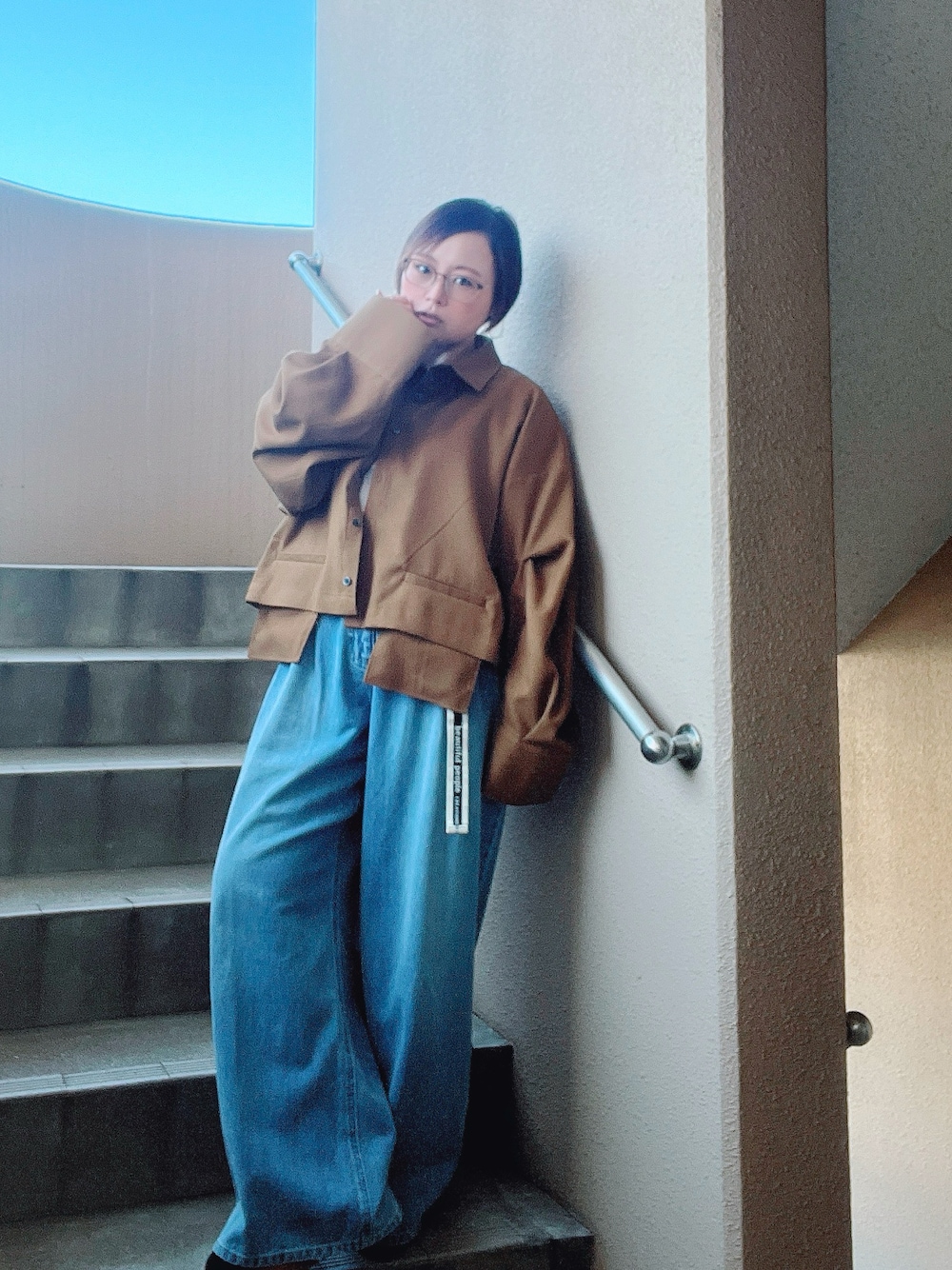 イエロー系のシャツ/ブラウス、ブルー系のデニムパンツ、ホワイト系のタンクトップを着用したレディースの秋コーディネートの1枚目の写真