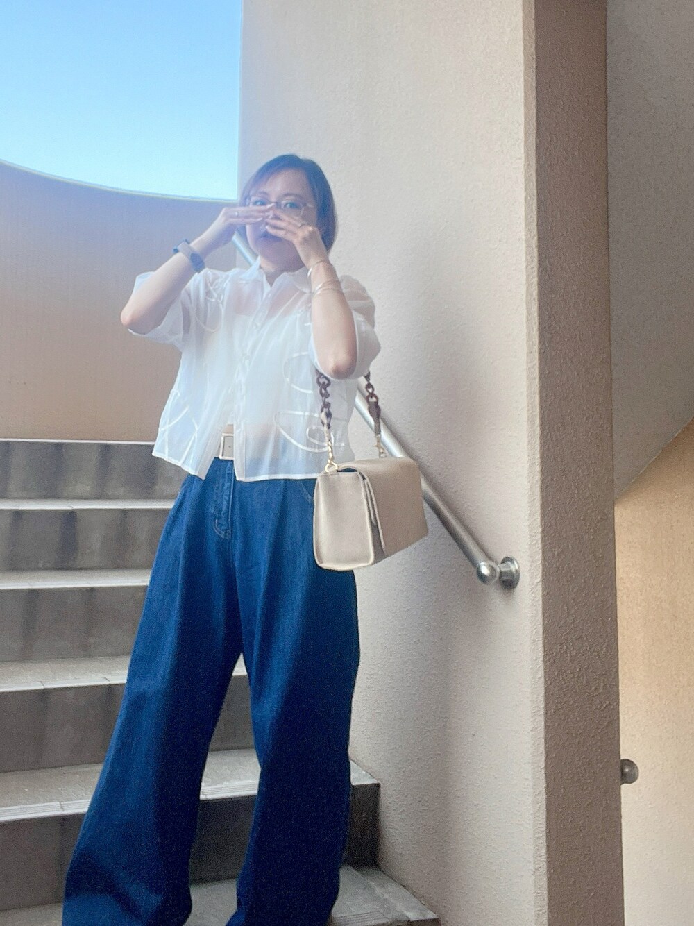 ブラック系のスニーカー、ブルー系のデニムパンツ、ホワイト系のシャツ/ブラウスを着用したレディースの夏コーディネートの1枚目の写真
