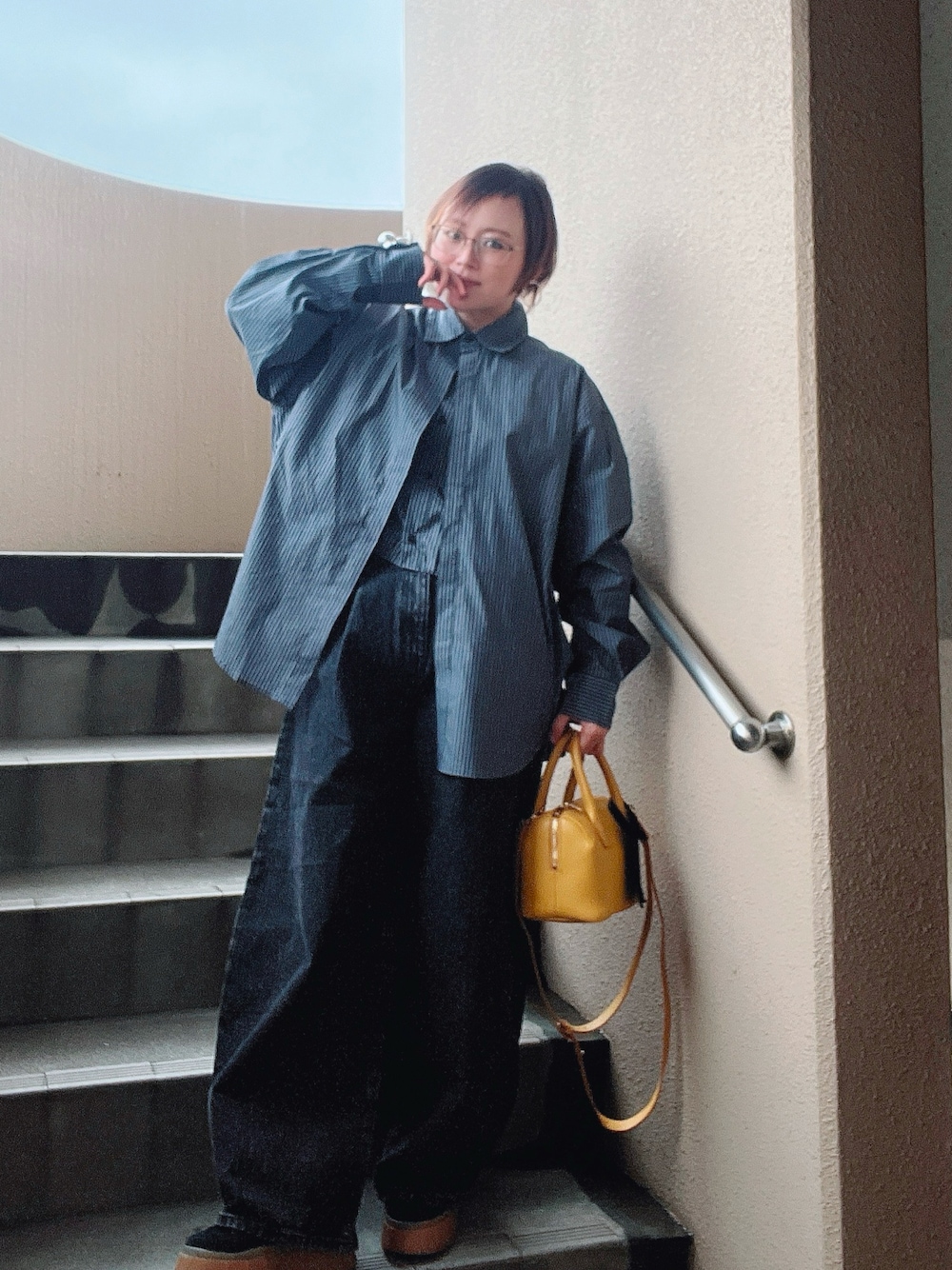 ブラック系のローファー、ブラック系のデニムパンツ、ブラック系のスニーカーを着用したレディースの秋コーディネートの1枚目の写真