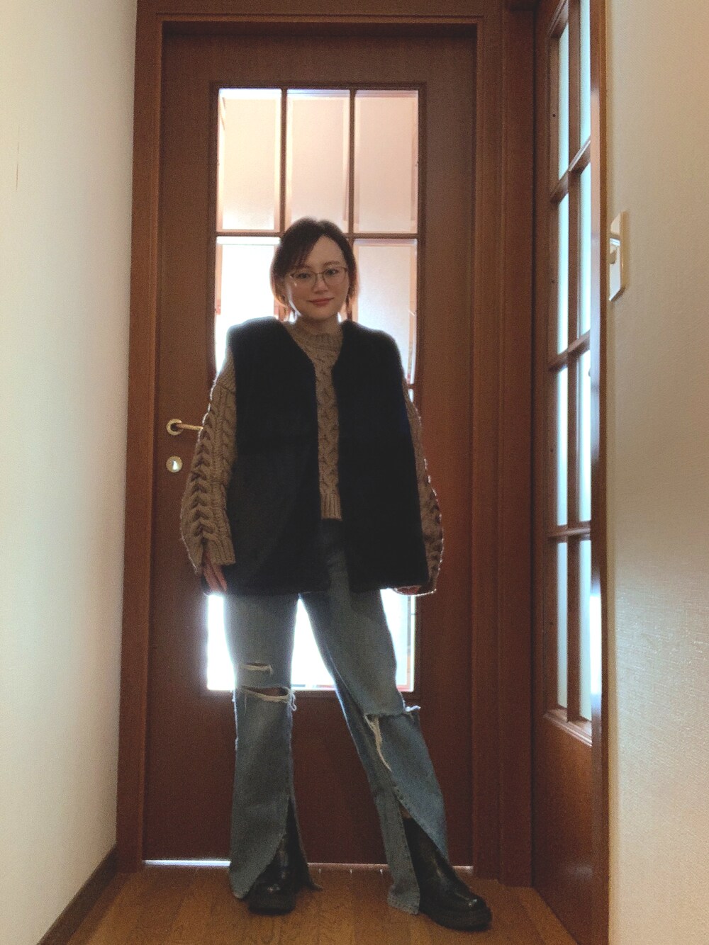 ブラック系のミリタリージャケット、ブラウン系のニット/セーター、ブルー系のデニムパンツを着用したレディースの冬コーディネートの1枚目の写真