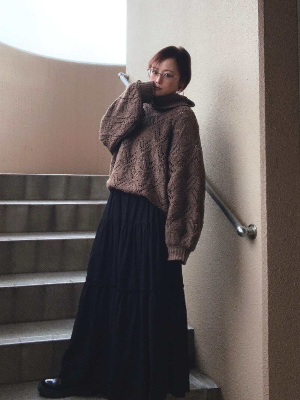 ブラウン系のニット/セーター、ブラック系のニット/セーター、ブラック系のスカートを着用したレディースの冬コーディネートの1枚目の写真