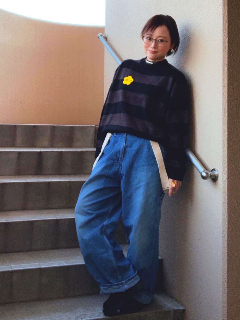 ブラック系のニット/セーター、ブルー系のサロペット/オーバーオール、ブラック系のブーツを着用したレディースの秋コーディネートの1枚目の写真