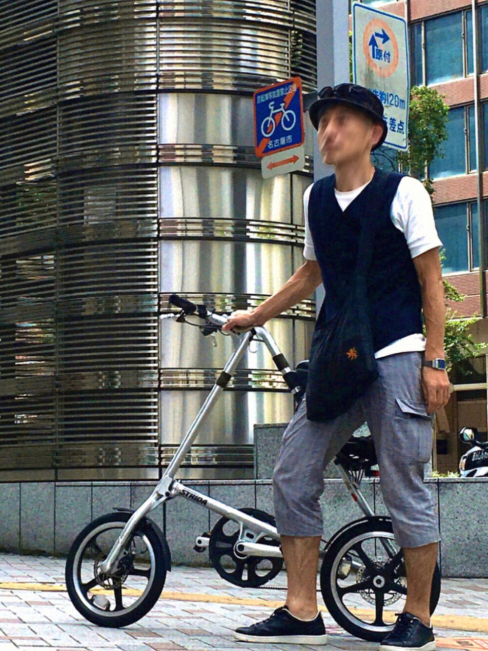 ホワイト系のベスト、グリーン系のショルダーバッグ、ブラック系のスニーカーを着用したメンズの夏コーディネートの1枚目の写真