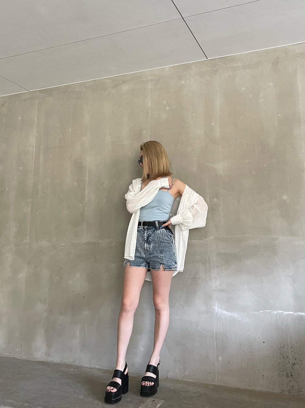 ブラック系のサンダル、ブルー系のデニムパンツ、ブルー系のキャミソールを着用したレディースの春コーディネートの1枚目の写真