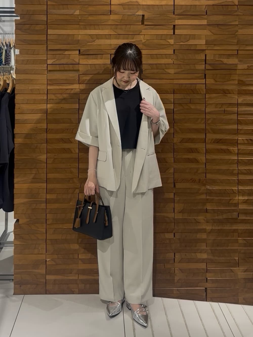 ベージュ系のその他アウター、ベージュ系のその他パンツ、ブラック系のハンドバッグを着用したレディースの春コーディネートの1枚目の写真