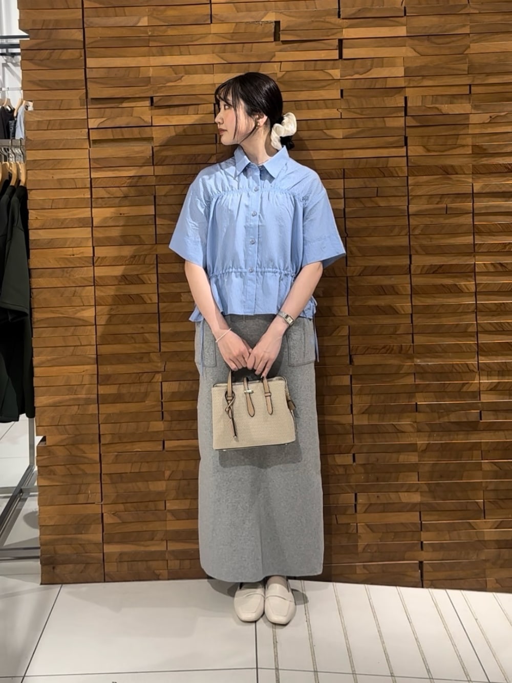 ブルー系のシャツ/ブラウス、グレー系のスカート、ホワイト系のトートバッグを着用したレディースの春コーディネートの1枚目の写真