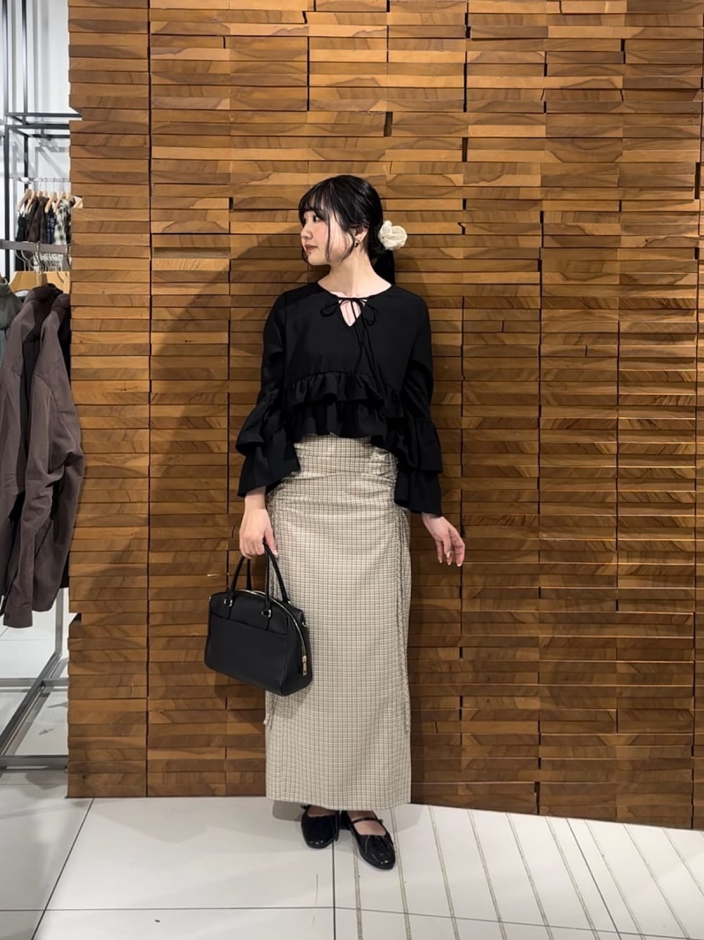 ブラック系のシャツ/ブラウス、ホワイト系のスカート、ブラック系のパンプスを着用したレディースの春コーディネートの1枚目の写真