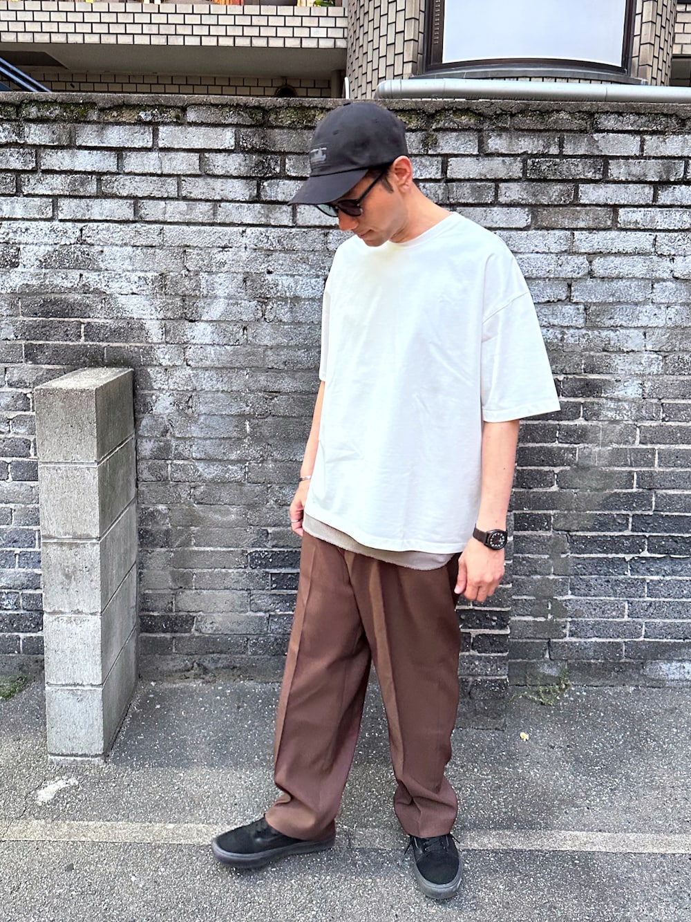 ホワイト系のTシャツ/カットソー、ベージュ系のタンクトップ、ブラウン系のスラックスを着用したメンズの春コーディネートの1枚目の写真