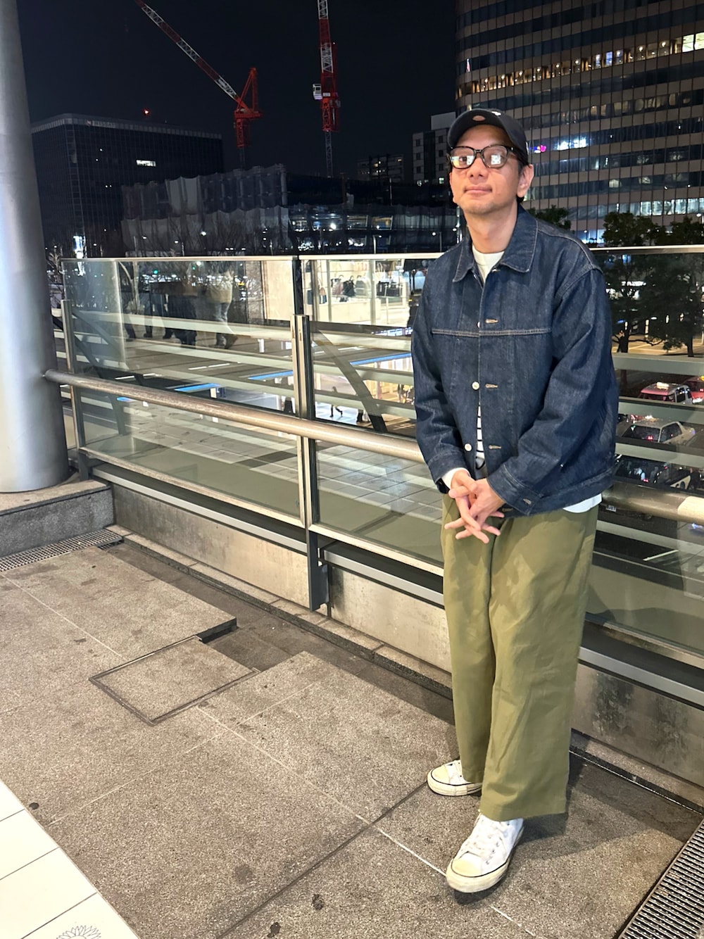 グリーン系のスラックス、ホワイト系のスニーカー、ブルー系のデニムジャケットを着用したメンズの春コーディネートの1枚目の写真