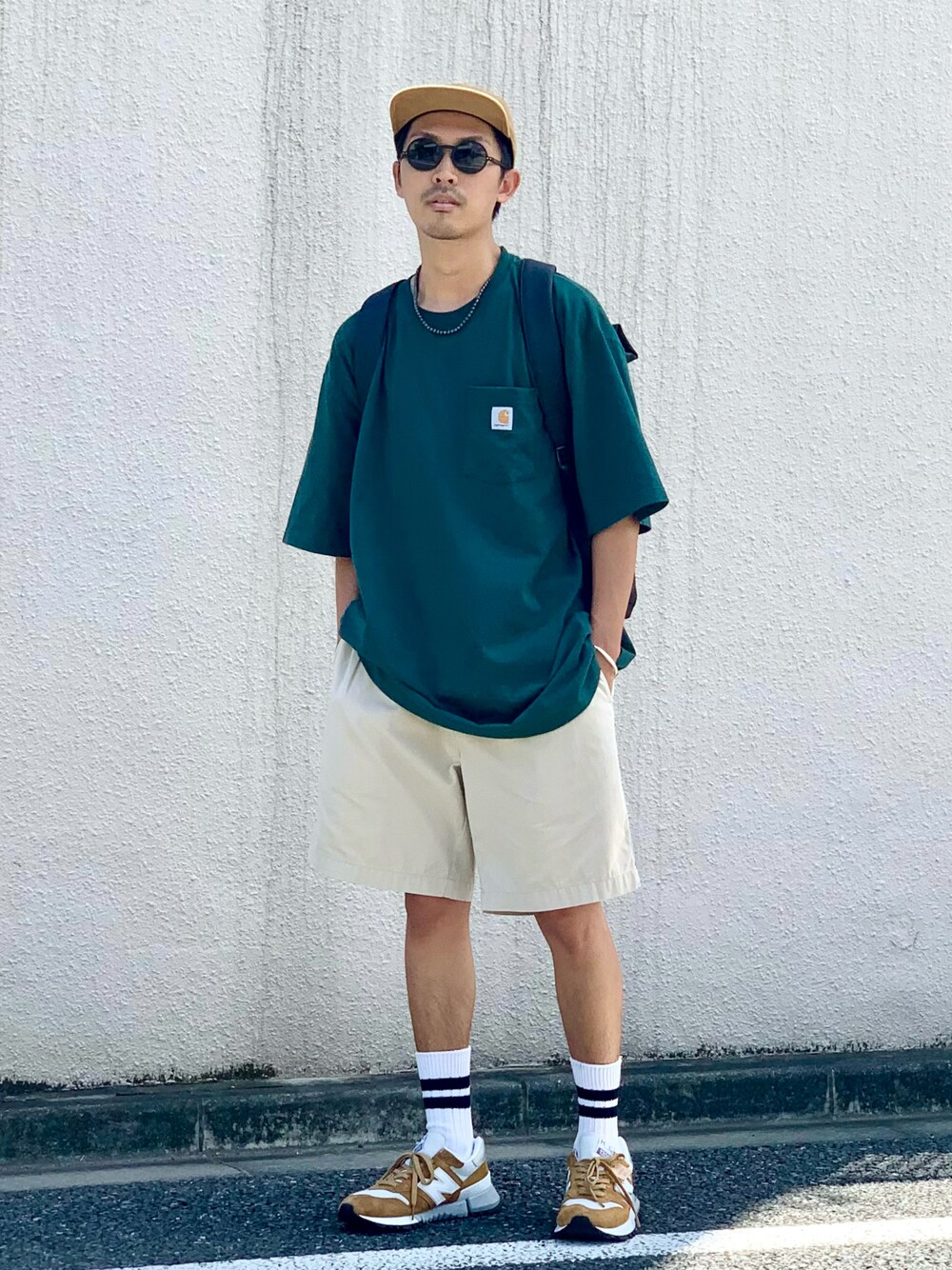 グリーン系のTシャツ/カットソー、ベージュ系のパンツ、イエロー系のスニーカーを着用したメンズの夏コーディネートの1枚目の写真
