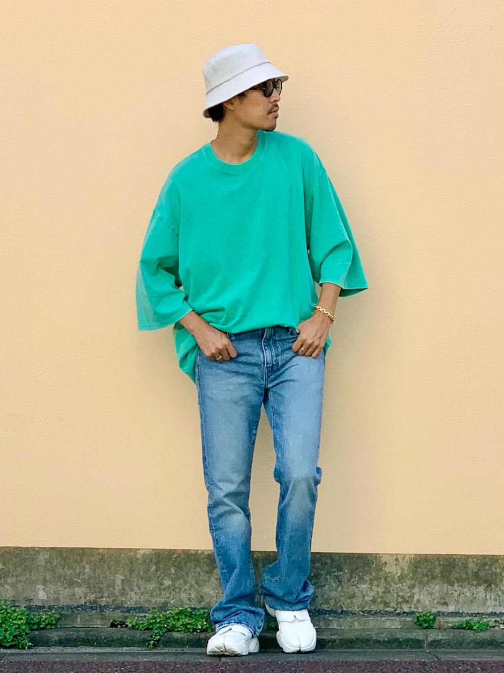 グリーン系のTシャツ/カットソー、ブルー系のデニムパンツ、ホワイト系のサンダルを着用したメンズの夏コーディネートの1枚目の写真