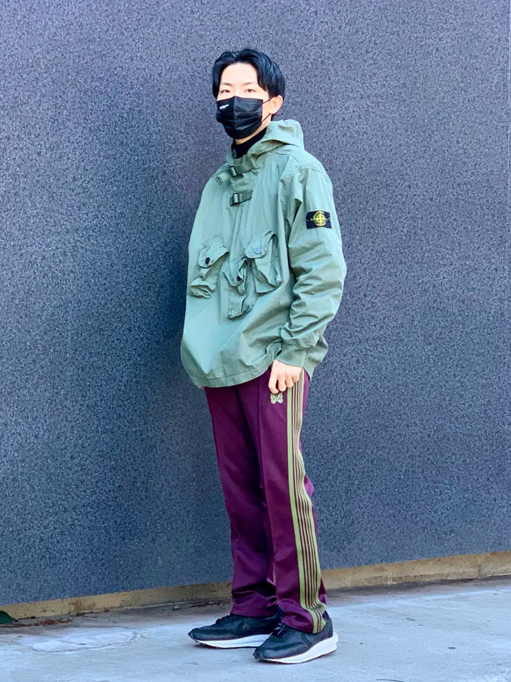 グリーン系のトップス、ブラック系のTシャツ/カットソー、パープル系のパンツを着用したメンズの冬コーディネートの1枚目の写真