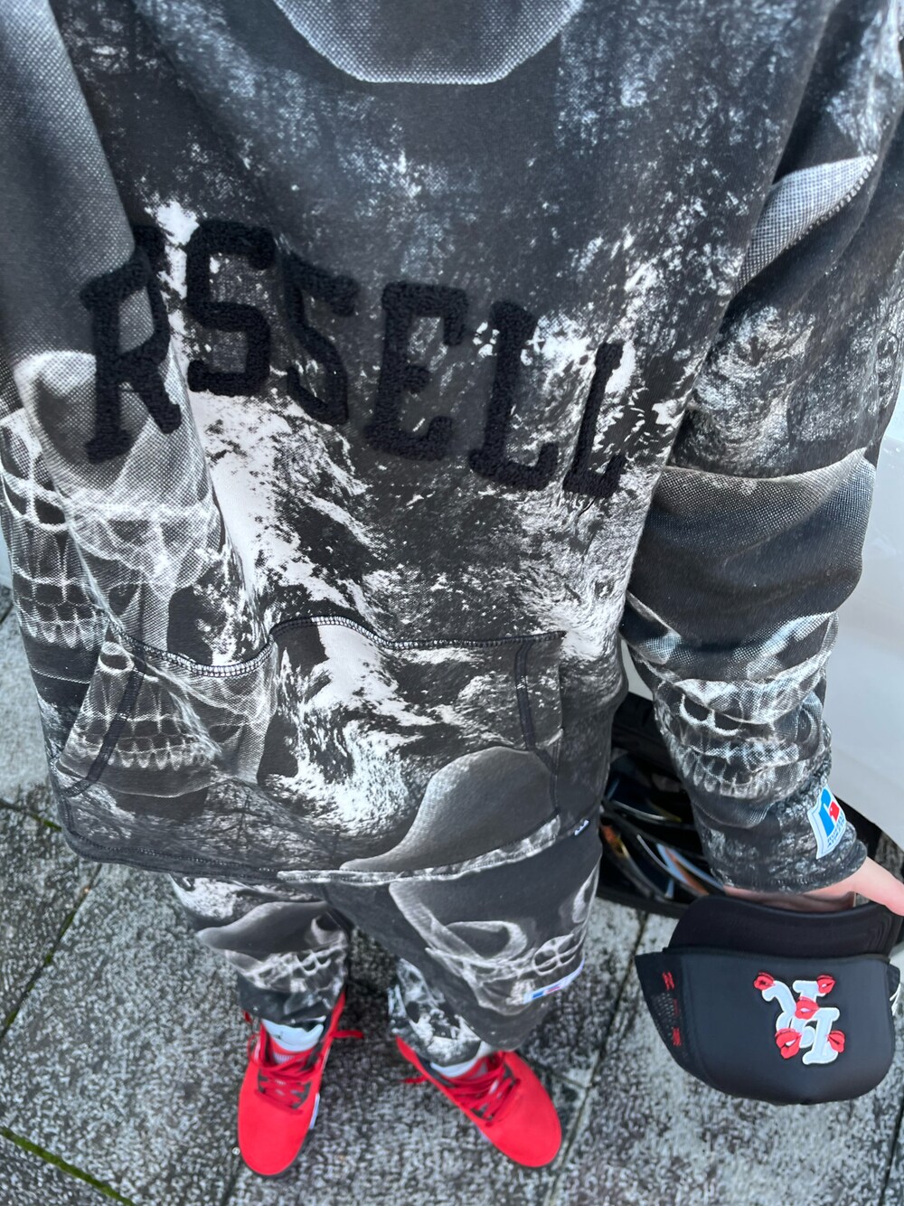 レッド系のスニーカー、ブラック系のパーカーを着用したメンズの秋コーディネートの1枚目の写真