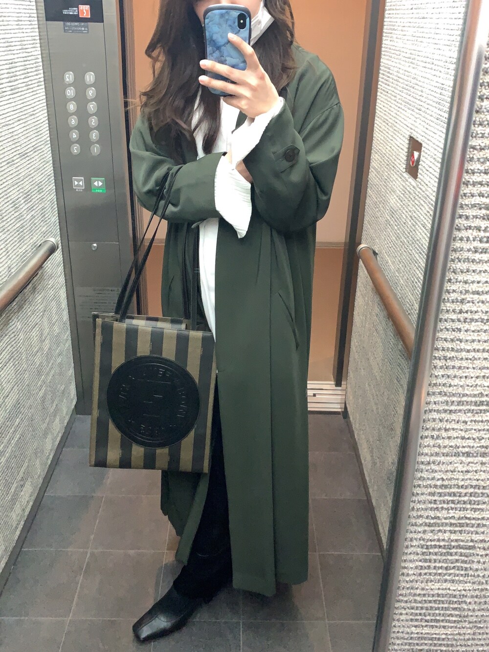 ブラック系のブーツ、ホワイト系のトップス、ホワイト系のシャツ/ブラウスを着用したレディースの冬コーディネートの1枚目の写真