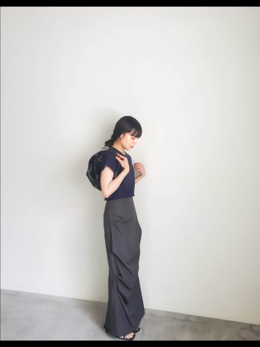 ブルー系のTシャツ/カットソー、ブラック系のスカート、ブラック系のショルダーバッグを着用したレディースの夏コーディネートの1枚目の写真