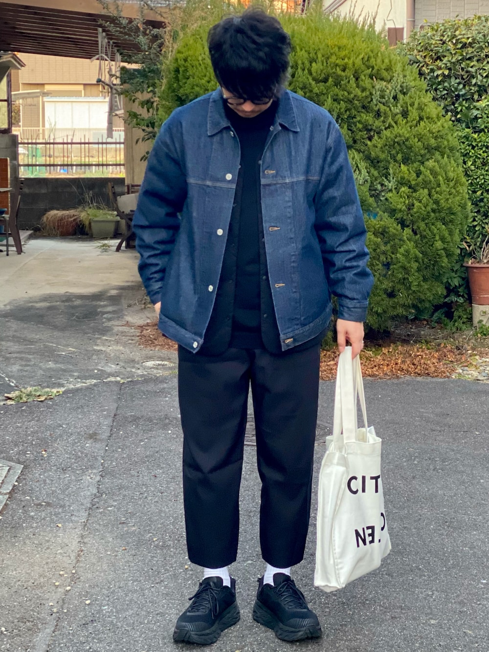 ブラック系のニット/セーター、ブルー系のデニムジャケット、ブラック系のダウンジャケット/コートを着用したメンズの冬コーディネートの1枚目の写真