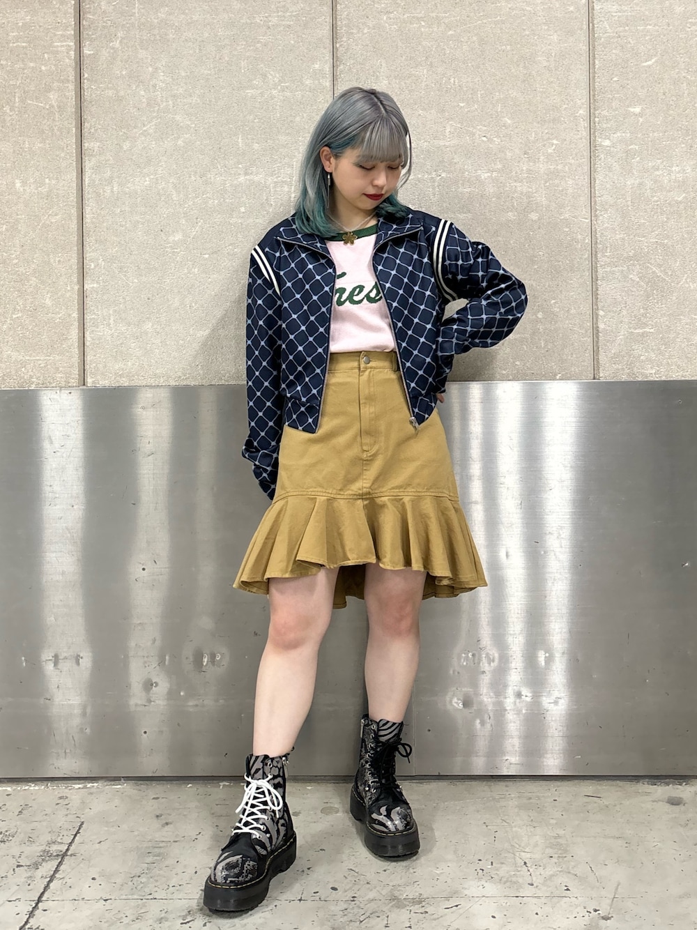 ベージュ系のスカート、ピンク系のニット/セーター、ブルー系のジャージを着用したレディースの春コーディネートの1枚目の写真