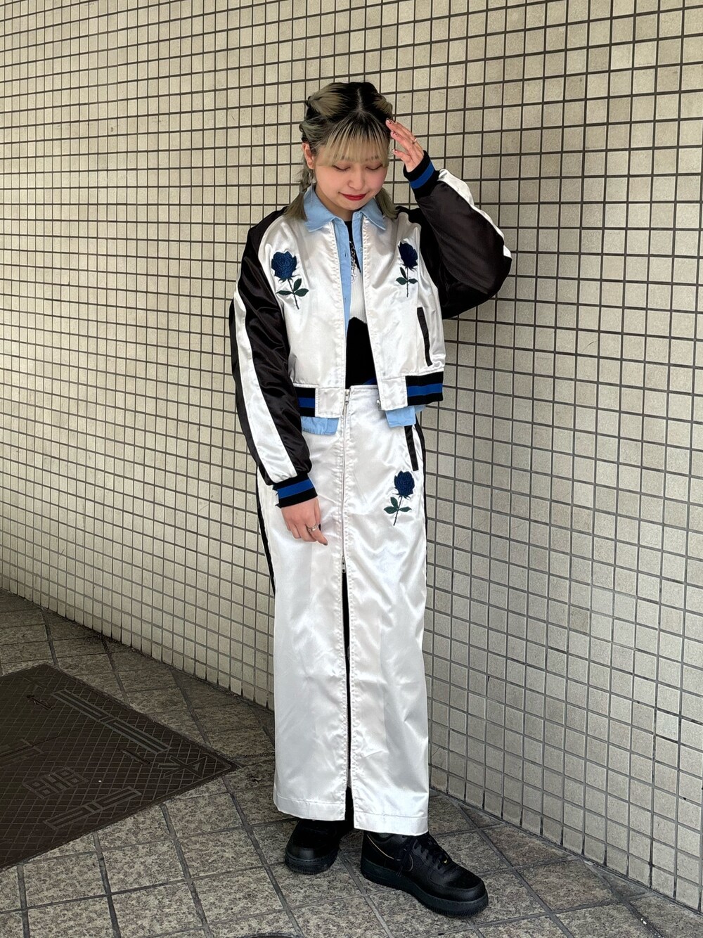 ホワイト系のスカート、ブルー系のシャツ/ブラウス、ブラック系のニット/セーターを着用したレディースの春コーディネートの1枚目の写真