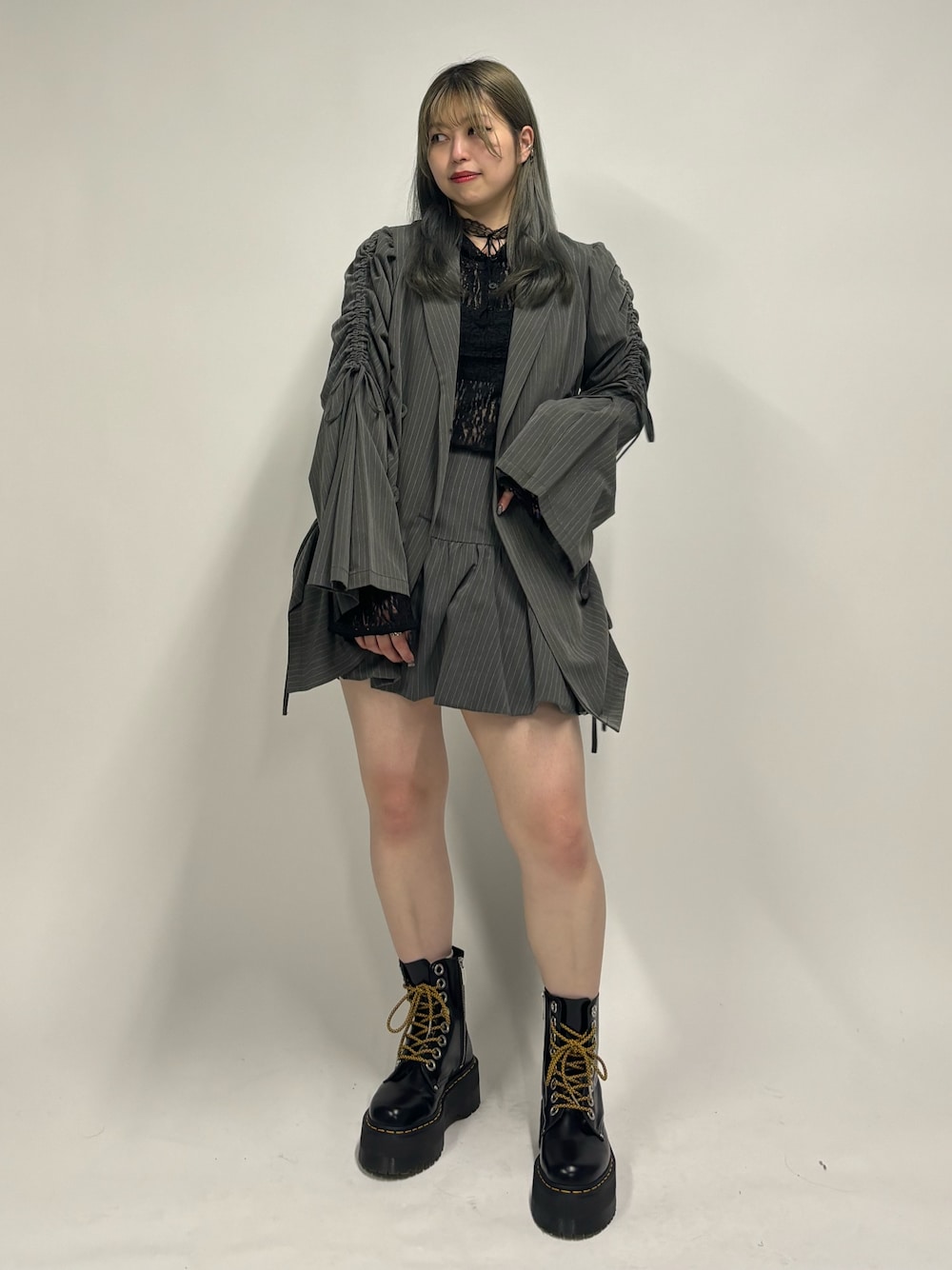 グレー系のスカート、ブラック系のその他シューズ、ブラック系のTシャツ/カットソーを着用したレディースの夏コーディネートの1枚目の写真