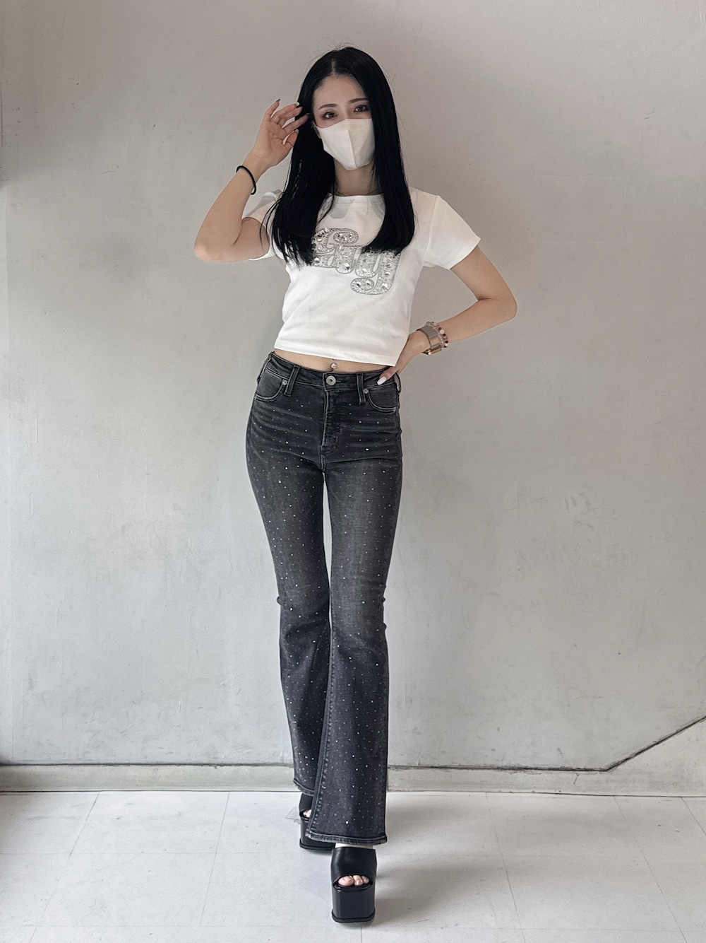 ホワイト系のTシャツ/カットソー、ブラック系のデニムパンツ、ブラック系のサンダルを着用したレディースの春コーディネートの1枚目の写真