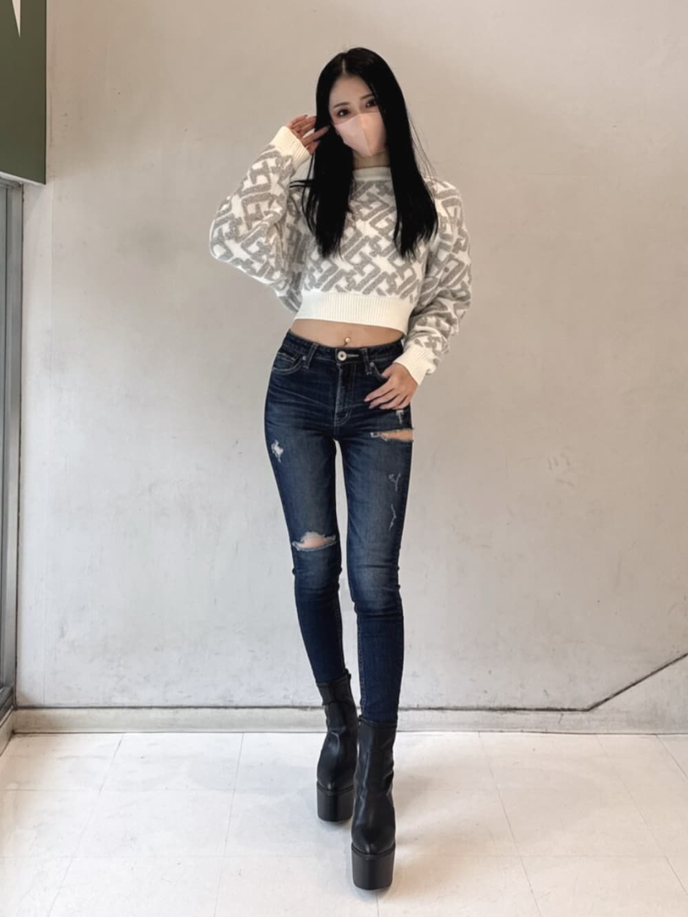 ブラック系のブーツ、ホワイト系のニット/セーター、ブルー系のデニムパンツを着用したレディースの冬コーディネートの1枚目の写真