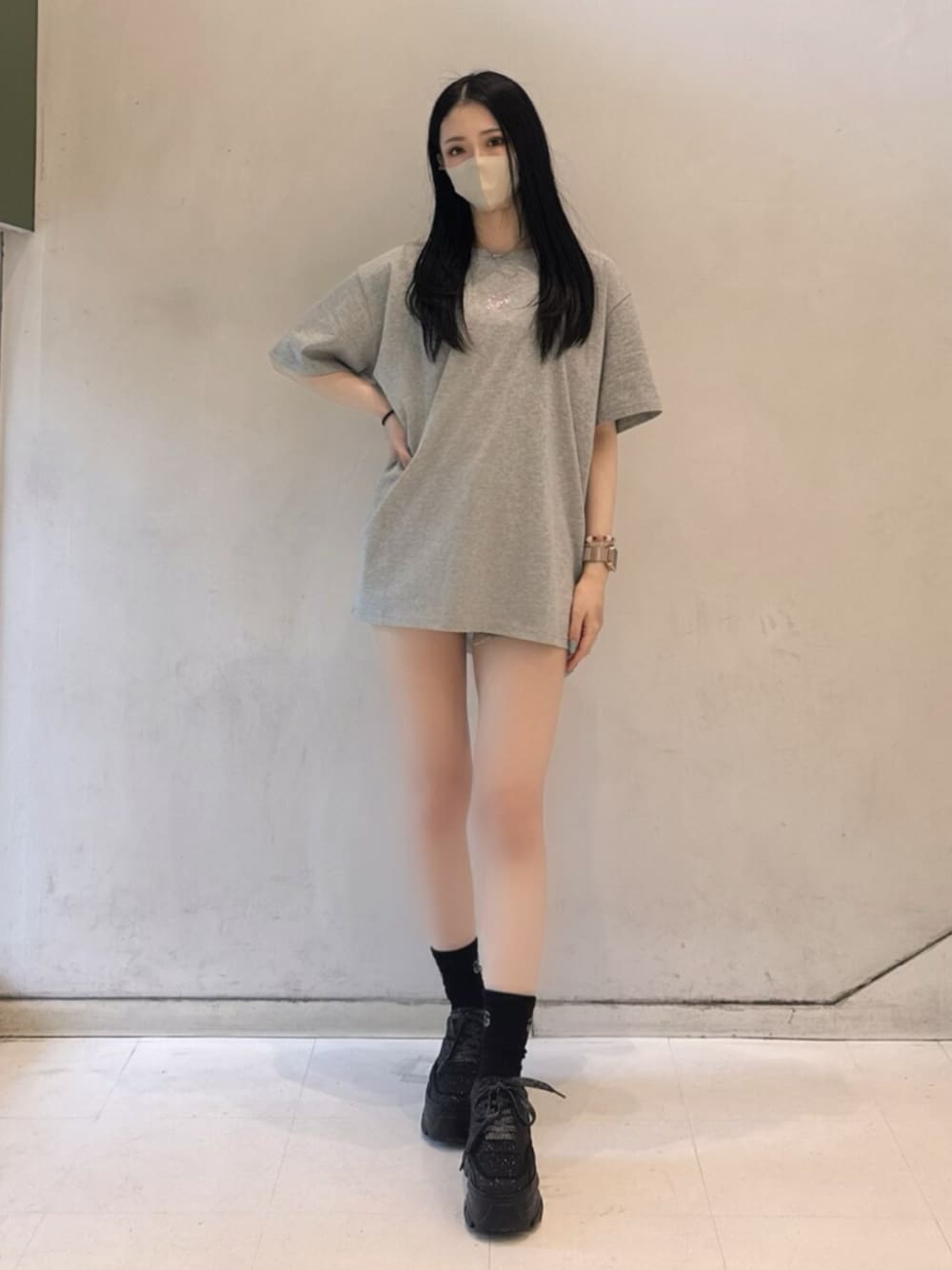 グレー系のTシャツ/カットソー、ブルー系のデニムパンツ、ブラック系のスニーカーを着用したレディースの春コーディネートの1枚目の写真