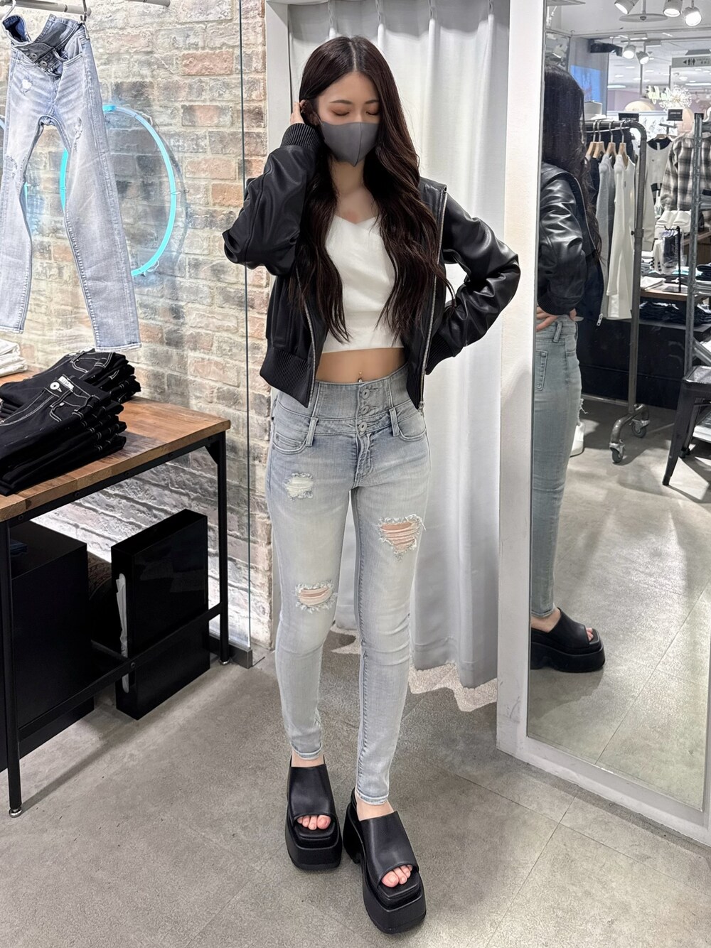 ブルー系のデニムパンツ、ホワイト系のTシャツ/カットソー、ブラック系のブルゾンを着用したレディースの春コーディネートの1枚目の写真