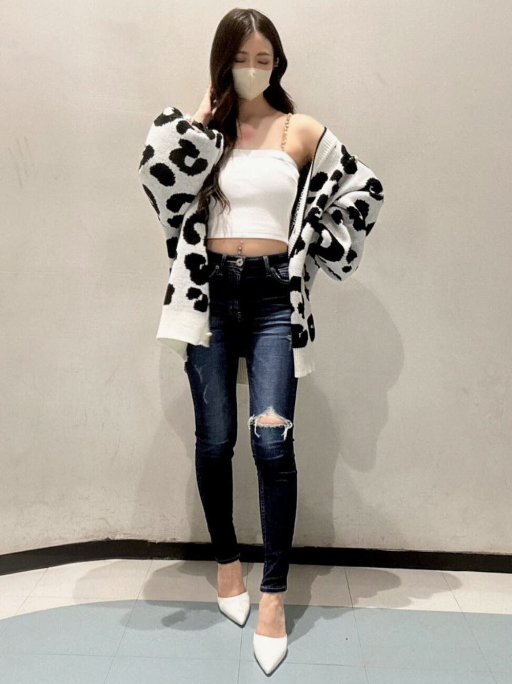 ホワイト系のカーディガン/ボレロ、ホワイト系のキャミソール、ブルー系のデニムパンツを着用したレディースの春コーディネートの1枚目の写真