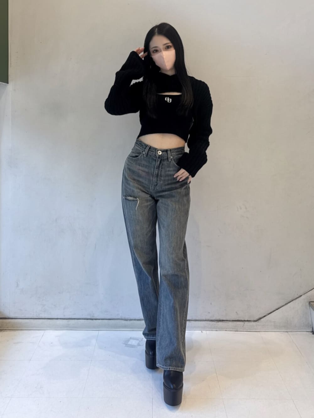 ブラック系のニット/セーター、ブルー系のデニムパンツ、ブラック系のブーツを着用したレディースの冬コーディネートの1枚目の写真